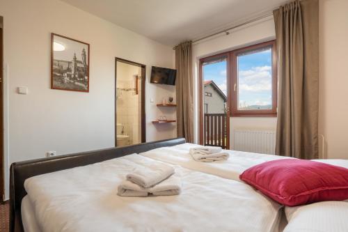 a bedroom with a large bed with towels on it at Penzion Balcony in Český Krumlov