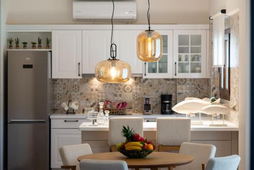 a kitchen with a table with a bowl of fruit on it at Valtos Beach Hotel in Parga