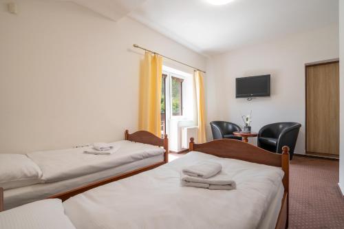 a hotel room with two beds and a tv at Penzion Balcony in Český Krumlov