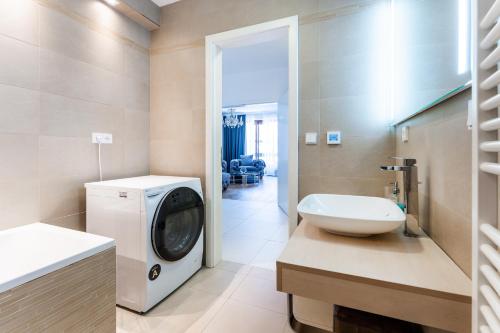 a bathroom with a washing machine and a sink at Apartmán Ondřejská 2159 Karlovy Vary in Karlovy Vary
