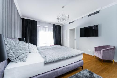 Apartmán Ondřejská 2159 Karlovy Vary في كارلوفي فاري: غرفة نوم بيضاء بسرير وكرسي