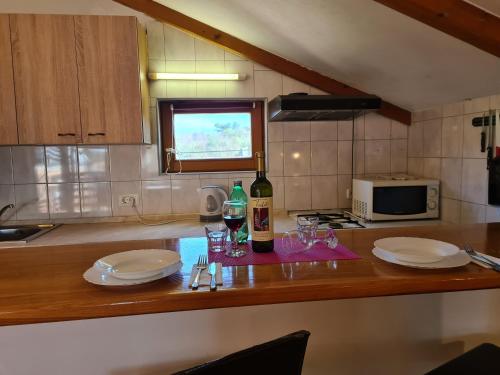 a kitchen with a table with glasses and a bottle of wine at Apartments Šeherzada in Pula