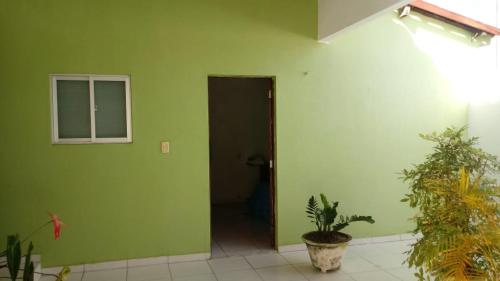 une salle verte avec une porte et quelques plantes dans l'établissement CASA De MÃE - CAMPINA GRANDE, à Campina Grande