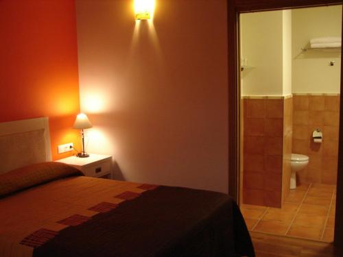 a bedroom with a bed and a bathroom with a toilet at Agroturismo La Casa Vieja in Maturana