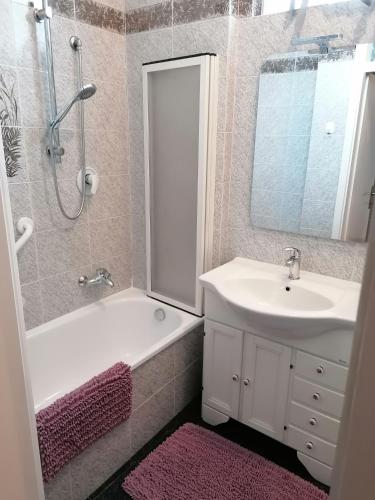 uma casa de banho com um lavatório, uma banheira e um chuveiro em B&B RINGAT em Mori