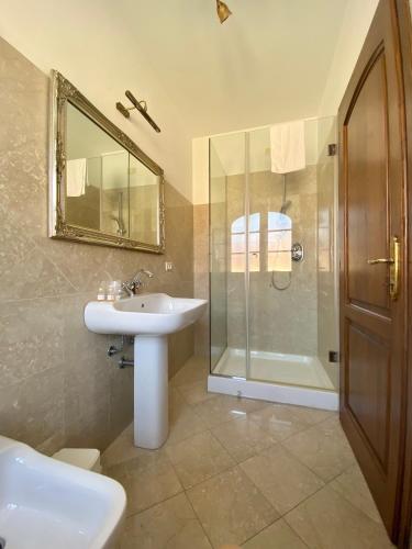 a bathroom with a sink and a shower and a mirror at Villa Silvana in Querceta