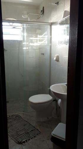 a bathroom with a shower and a toilet and a sink at Pouso Mariazinha in Tiradentes