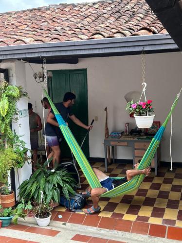 two people are laying in hammocks on a house at Green Door San Gil in San Gil