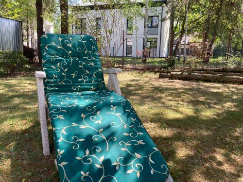 a green chair sitting in the grass in a yard at Dom Chotomów in Chotomów