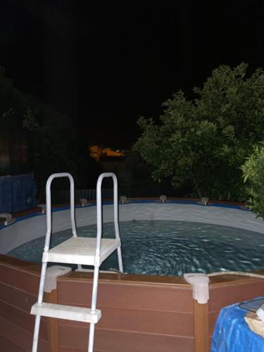 a white chair sitting in a pool at night at Casa da Vila in Penamacor
