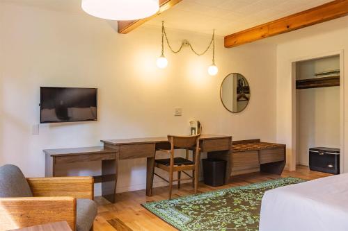 a living room with a desk and a tv at The Grayhaven Motel in Ithaca