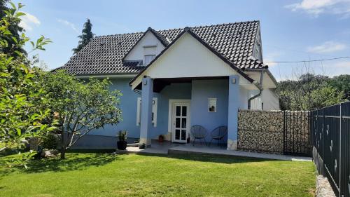 una casa blanca con una valla y un patio en Jenny vendégház en Zalakaros