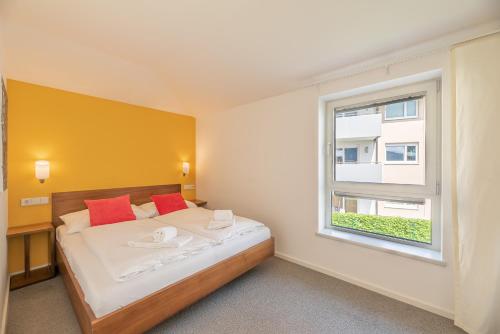 a small bedroom with a bed and a window at Finest Apartments Glacier View by All in One Apartments in Kaprun