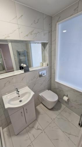 a white bathroom with a sink and a toilet at Best Western Northfields Ealing Hotel in London