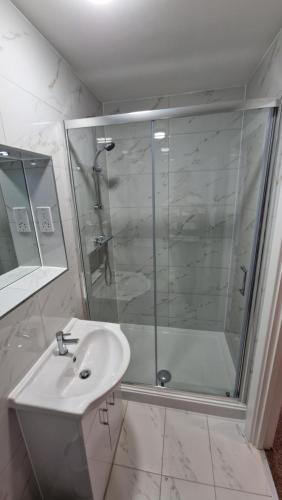 a white bathroom with a shower and a sink at Best Western Northfields Ealing Hotel in London