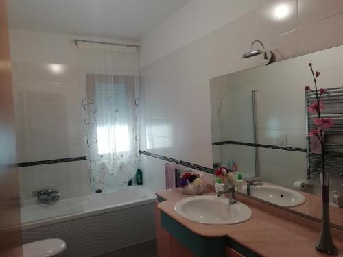 ein Badezimmer mit einem Waschbecken, einer Badewanne und einem Spiegel in der Unterkunft Da Luigi locazioni brevi turistiche in Monopoli