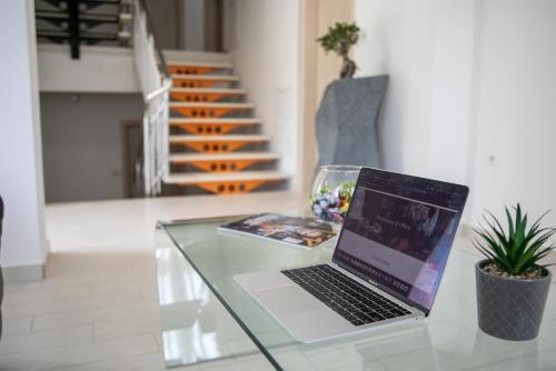 a laptop sitting on a glass table in a room at Happy Hill Rooms in Banja Luka