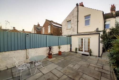 a patio with a table and chairs in front of a fence at Welcoming 4 Bed Holiday Home in Eastbourne in Eastbourne