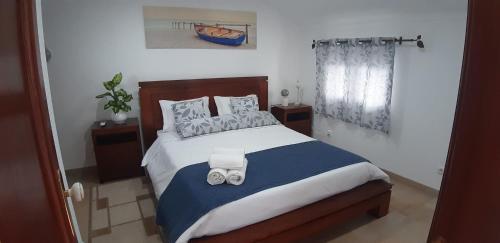 a bedroom with a bed with two towels on it at A Casa da Foz Moradia com vista mar in Sesimbra