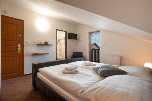 a bedroom with a bed with towels on it at Penzion Balcony in Český Krumlov