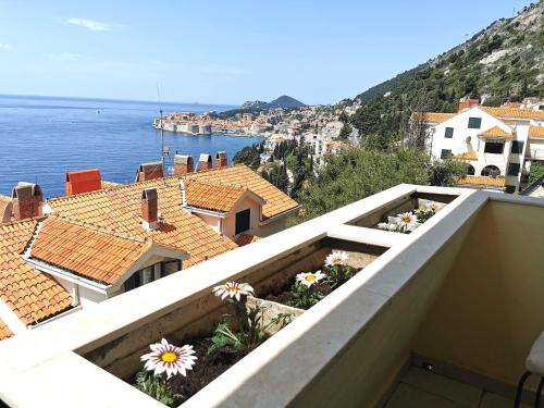 een balkon met uitzicht op de oceaan en gebouwen bij Apartment Zlatni Potok - View of the Old Town & 15 Minute Walk to the Center in Dubrovnik