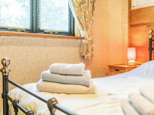 a pile of towels sitting on top of a bed at Endymion in Fritham