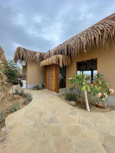 a house with a thatched roof and a patio at Villas turrutela in Los Órganos