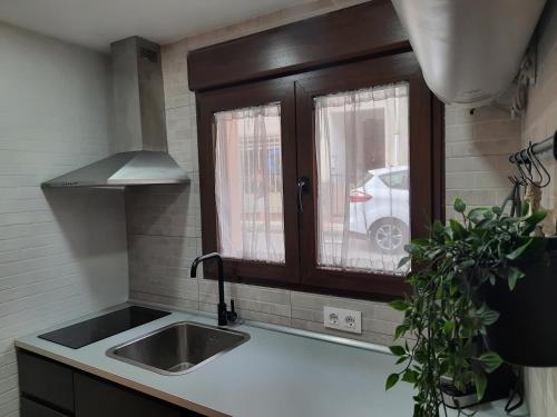 eine Küche mit einem Waschbecken und einem Fenster in der Unterkunft Casa El Viaje in San Leonardo de Yagüe