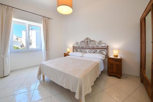 sypialnia z dużym łóżkiem i oknem w obiekcie La Dimora Dei Nonni w mieście Ischia