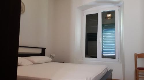 Habitación blanca con cama y ventana en Villa Jelka Apartment, en Zaton