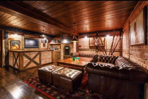 a living room with a leather couch and a table at WILLA NAD STAWEM MAZURY in Piecki
