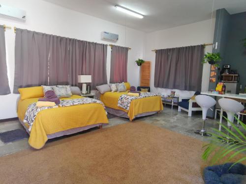 Michelle's Place في كابو سان لوكاس: غرفة نوم بسريرين وطاولة وكراسي