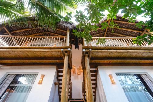 - un bâtiment avec un plafond et des fenêtres en bambou dans l'établissement Nomads Flats, à Itacaré