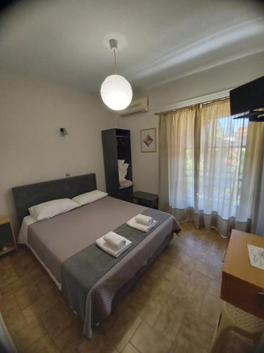 1 dormitorio con 1 cama con 2 toallas en Anesi Rooms To Rent, en Olimpia