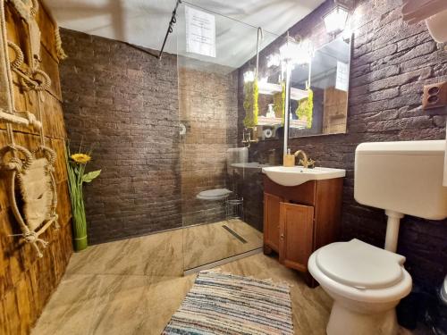 a bathroom with a toilet and a sink and a mirror at Lângă Stână in Curtea de Argeş