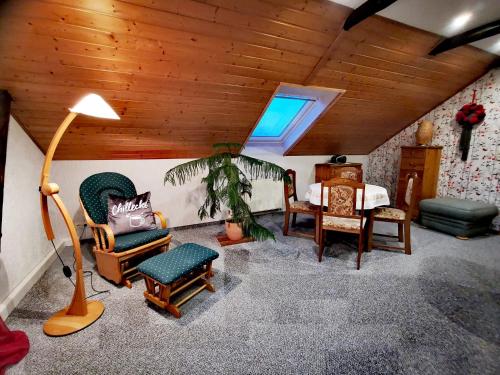 sala de estar con sillas, mesa y lámpara en Ferienwohnung auf dem Fischer-Hof, en Stolpen