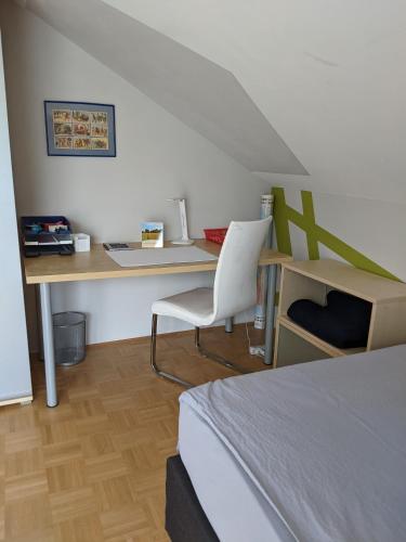 a bedroom with a desk and a bed and a chair at Ferienhaus Lindelburg in Schwarzenbruck