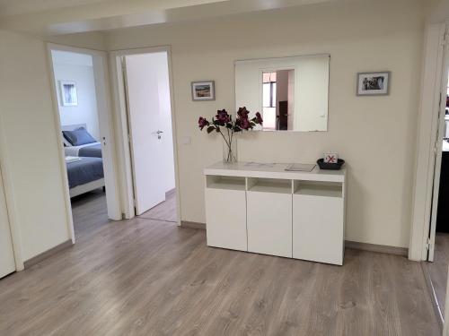 a white kitchen with a counter with a vase of flowers at StaynFeel 03 in Fátima