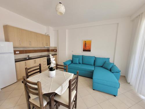 a living room with a blue couch and a table at Parid Appartments in Sarandë