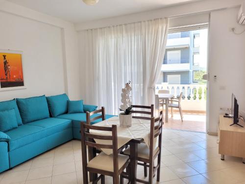 a living room with a blue couch and a table at Parid Appartments in Sarandë