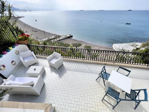a patio with white furniture and a view of the beach at Due Relais - Panoramic Sea View Suites in Vietri sul Mare