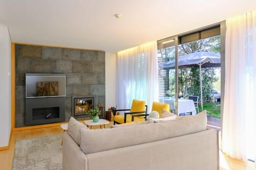 a living room with a couch and a fireplace at Moradia Prime em Tróia com Piscina Privada in Troia