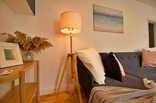 un soggiorno con divano blu e lampada di 'Bridgewater' at stayBOOM a Morecambe
