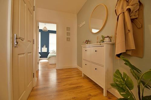 a hallway with a white cabinet and a mirror at 'Bridgewater' at stayBOOM in Morecambe