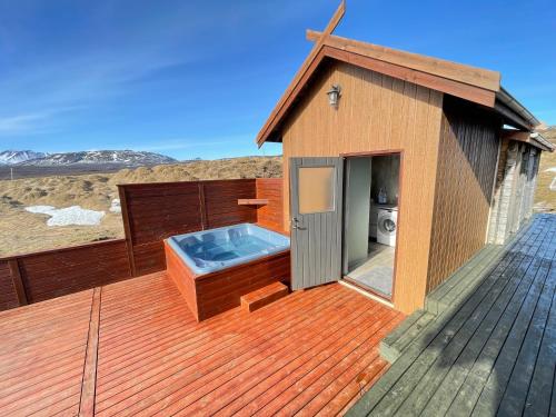 a hot tub on the deck of a house at Dalsmynni in Blaskogabyggo
