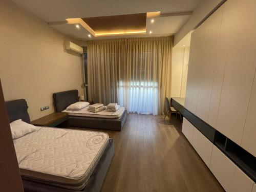 um quarto de hospital com duas camas e uma janela em MAK Apartments em Tirana