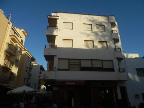 a tall white building with a lot of windows at Apartamentos Pescadores in Peniscola