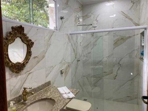 a bathroom with a shower and a sink and a mirror at Flores de Cunha in Cunha