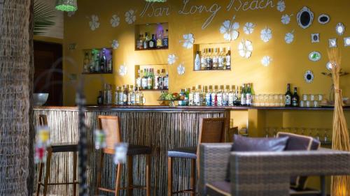 a bar with chairs and bottles on the wall at Long Beach in Canoa Quebrada