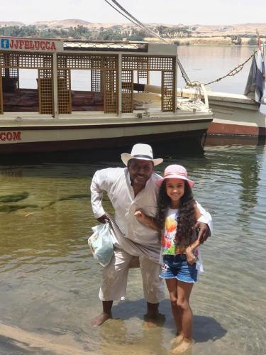a man and a little girl standing in the water at Go Inn Backpackers in Aswan